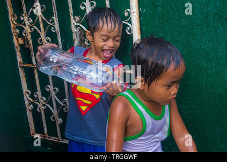 Un enfant joue avec l'eau pendant le festival de Higantes à Angono Philippines Banque D'Images