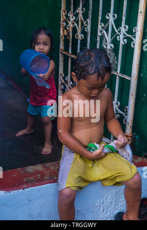 Un enfant joue avec l'eau pendant le festival de Higantes à Angono Philippines Banque D'Images