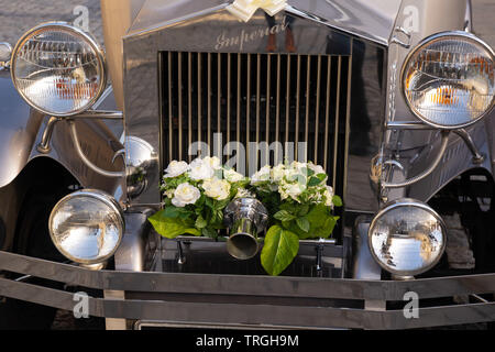 L'avant d'une voiture de mariage Imperial Launderlette argentée décorée de lapins de roses blanches, Leeds, West Yorkshire, Angleterre, Royaume-Uni. Banque D'Images