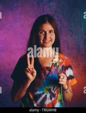 Hippie woman holding up part en signe de la paix Banque D'Images