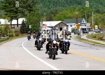 Un groupe de motos qui traversent le village de spéculateur, NY USA sur une promenade dans les montagnes Adirondack dans le cadre d'Americade 2019. Banque D'Images