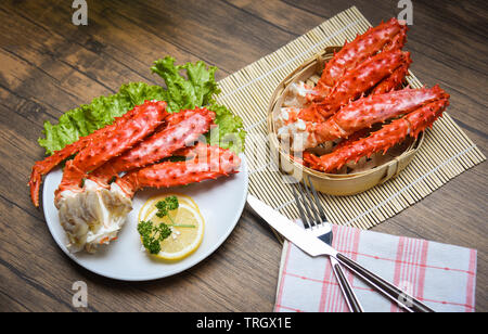 King Crabe d'Alaska cuit sur plaque blanche avec laitue persil citron et légumes vapeur en bambou sur fond de bois / crabe rouge des fruits de mer d'Hokkaido Banque D'Images