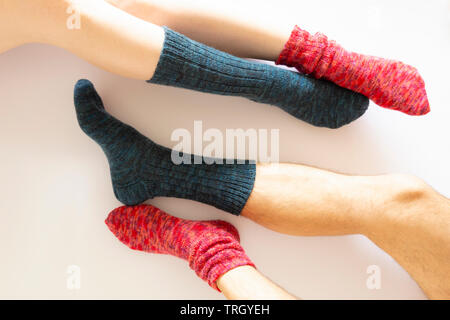 Vue de dessus deux paires de pattes portant un rouge et une chaussette bleu sur fond blanc Banque D'Images