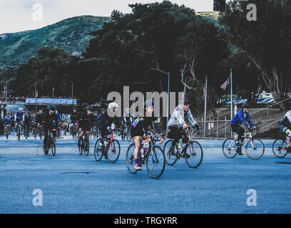 San Francisco, USA. 2 juin, 2019. Les cyclistes quittent le Cow Palace au début de la SIDA ou le cycle de vie tout comme le soleil atteint le sommet des collines au-dessus. Banque D'Images