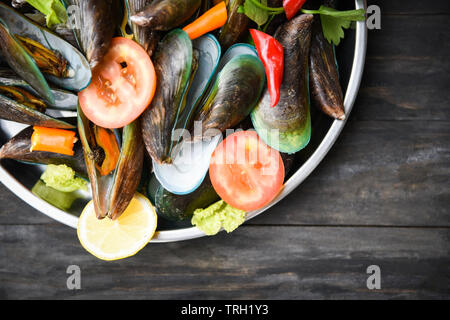 Les moules avec des herbes et des épices dans le bac vert cuit vapeur moules fruits de mer Banque D'Images