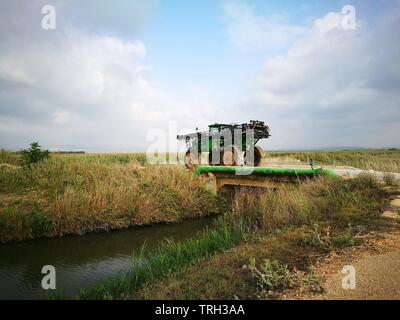 Une moissonneuse-batteuse (abatteuse) traverser un petit pont en béton Banque D'Images