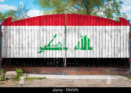 Close-up du drapeau national de l'Iraq sur une barrière en bois à l'entrée du territoire fermé un jour d'été. Le concept de stockage de marchandises, l'entrée Banque D'Images