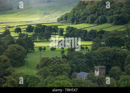 Une tache de lumière fugace sur Arncliffe Church & Littondale sous la pluie, dans le Yorkshire Dales National Park, England, UK Banque D'Images