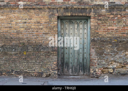 Ancien s'est évanoui dans la vieille porte turquoise weathered brick wall, Newmarket, England, UK Banque D'Images