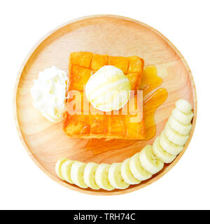 Toast avec du miel banane sur plaque de bois. Vue d'en haut. Toast de pain perdu avec glace vanille et Chantilly isolé sur fond blanc Banque D'Images