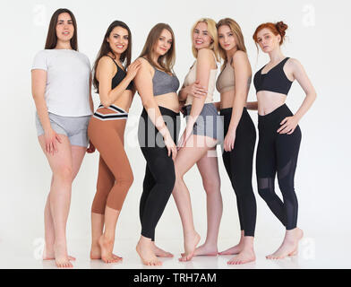 Heureux autre race women wearing sports top et leggings l'air parfaite et se sont réunis au studio de remise en forme pour la formation ensemble. La fema sportive multiraciale Banque D'Images