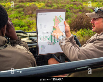 Un guide montre aux touristes un plan de Phinda Private Game Reserve, une réserve naturelle appartenant andBeyond dans l'Est de l'Afrique du Sud. Banque D'Images