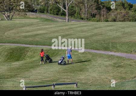 Un couple en train de marcher le fairway à Gardiners Bay Country Club de Shelter Island, NY Banque D'Images