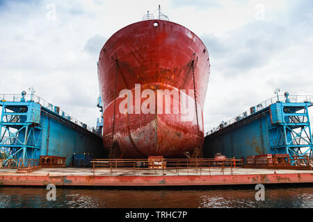 Tanker rouge énorme est en réparation en bleu dry dock. Vue de face. Chantier naval de Varna, Bulgarie Banque D'Images