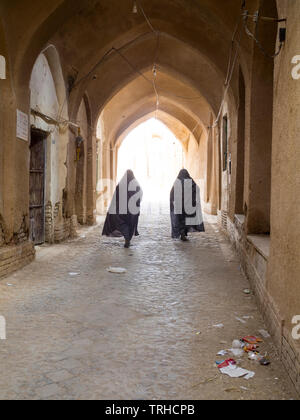 Deux femmes se promène dans le vieux bazar dans Aqda, Iran. La ville est actuellement en cours de restauration pour le tourisme. Banque D'Images