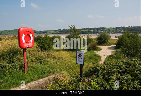 Chemin d'accès à une plage de la côte britannique, Ligne avec anneau de sauvetage dans l'avant-plan Banque D'Images