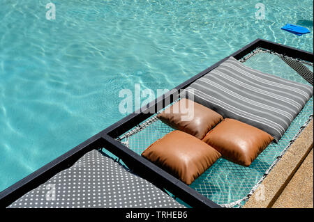 Siège mesh de relaxation avec des oreillers sortir sur piscine Banque D'Images