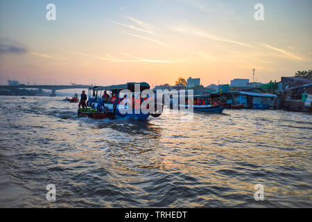 Can Tho, Vietnam - Mars 28, 2019 : les bateaux de croisière dans le Delta du Mékong. Bridge en arrière-plan au coucher du soleil. Les touristes dans les gilets orange. Banque D'Images