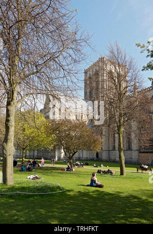 Les personnes qui apprécient les loisirs relaxants dans le parc du soleil de printemps Deans Park à côté du Minster York North Yorkshire England Royaume-Uni GB Grande-Bretagne Banque D'Images