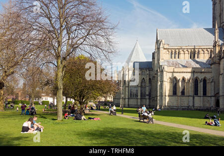 Les personnes qui apprécient les loisirs relaxants dans le parc du soleil de printemps Deans Park à côté du Minster York North Yorkshire England Royaume-Uni GB Grande-Bretagne Banque D'Images