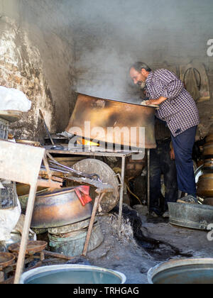 Un homme faisant des pots en cuivre dans le bazar de Kerman, Iran. Banque D'Images