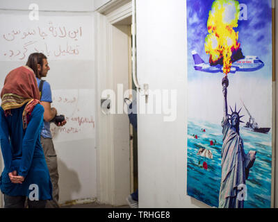 Les touristes marchent à côté d'une affiche rappelant le vol 655 de l'avion d'Iran qui a été abattu par la marine des États-Unis en 1988, tuant les 290 personnes à bord, l'Iran. Banque D'Images