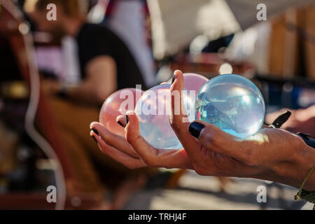 Sorcerer's hands holding jongler avec des boules de cristal au festival d'été de public Banque D'Images