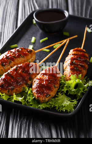 Harry est l'un des populaires yakitori (bouchées de poulet grillé en brochettes) des plats au Japon Gros plan sur une plaque verticale la table. Banque D'Images