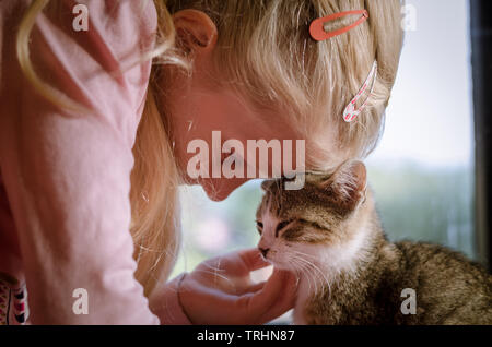 Belle fille blonde et happy cat ensemble Banque D'Images