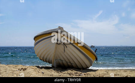 Petit bateau amarré sur une plage sur la mer Égée. Banque D'Images