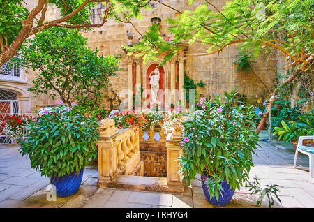 La Valette, MALTE - 17 juin 2018 : le vert petit jardin avec fontaine et sculpture antique situé dans la cour de Cassa historique Rocca Picola pala Banque D'Images