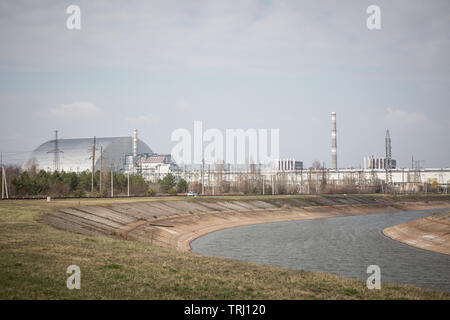 Tchernobyl, l'Ukraine. 10 avril, 2019. La nouvelle enceinte de confinement du réacteur demeure couvre le numéro 4 de la centrale nucléaire de Tchernobyl, détruit dans la catastrophe de Tchernobyl en 1986. L'usine se trouve maintenant dans la zone d'exclusion de Tchernobyl en Ukraine. Banque D'Images