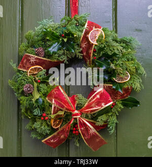 Une couronne de Noël suspendu à une porte verte Banque D'Images