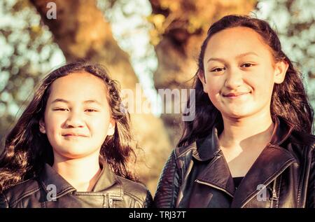 Portrait de deux jeunes sœurs Maori pris à l'extérieur dans un parc. Banque D'Images