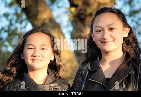 Portrait de deux jeunes sœurs Maori pris à l'extérieur dans un parc. Banque D'Images