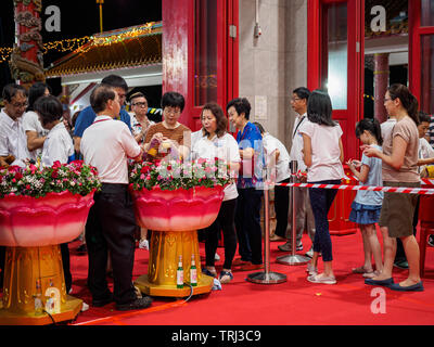 Singapour, 18 mai 2019 - Les dévots effectuer le bain rituel du Bouddha au temple sur la Colline lumineuse Journée du Vesak Banque D'Images