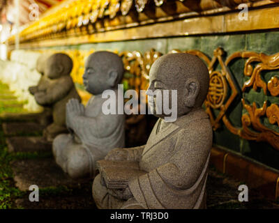 Singapour, 18 mai 2019 - Close up vue latérale des statues en pierre de moines bouddhistes sitting cross legged à temple Hill lumineux sur la Journée du Vesak Banque D'Images