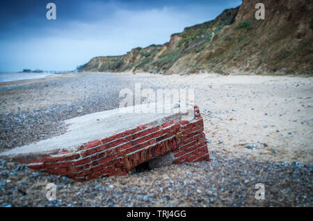 Ce qui ressemble à un bunker militaire au lavage d'une falaise érodée à Norfolk Banque D'Images