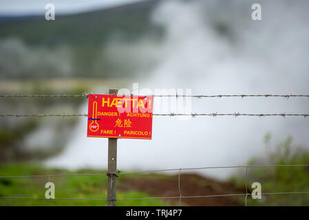 Attention danger dans différentes langues à proximité d'une source d'eau chaude géothermique de bouillante en Islande Banque D'Images