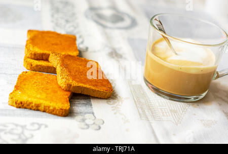 Groupe des biscuits avec de la confiture se propager avec une tasse de cappuccino sur une table avec la nappe décorée. Le petit déjeuner du matin. L'alimentation saine et le mode de vie Banque D'Images