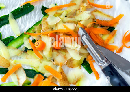 Pelures de légumes carottes, pommes de terre et courgettes fraîchement pelés avec un couteau économe. Concept de l'alimentation et mode de vie sain. Banque D'Images