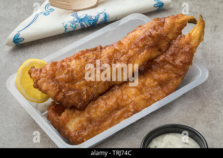 Filet de poisson frit, appelé lekkerbek en néerlandais servi avec sauce et de citron dans un plat de plastick close up Banque D'Images