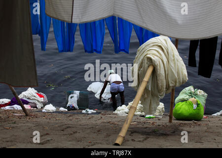 Des tabliers, des draps, des taies d'utilisé par les médecins et les patients à différents hôpitaux de Dacca sont régulièrement lavés dans la rivière polluée, Burhiganga t Banque D'Images