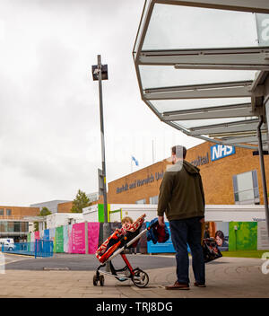 Norwich, Norfolk, Royaume-Uni. 18 mai 2019. Photos spontanées - homme attendant à l'extérieur à l'Hôpital Universitaire NHS Norwich avec sa petite fille dans une poussette en attente d'un taxi Banque D'Images