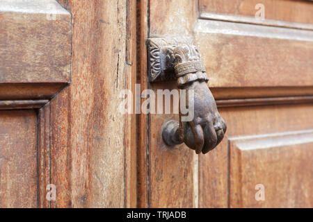 Ancien heurtoir de porte en forme de main et porte en bois historique Banque D'Images