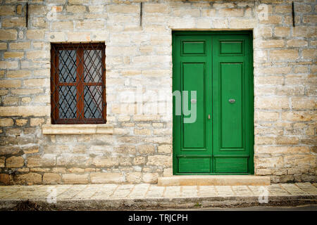 Détails de l'architecture de la Renaissance - en bois peint vert et porte fenêtre avec une grille d'une maison en pierre dans la ville de Kavarna, Bulgarie Banque D'Images