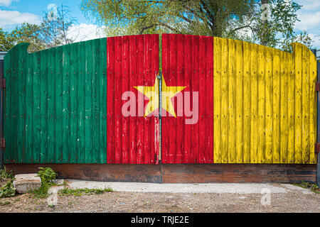 Close-up du drapeau national du Cameroun sur une barrière en bois à l'entrée du territoire fermé un jour d'été. Le concept de stockage de marchandises, e Banque D'Images