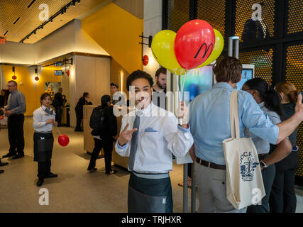 Un travailleur accueille de nouveaux clients entrant dans le McDonald's de Times Square à New York vu sur son grand jour d'ouverture, le jeudi 30 mai 2019. Les plus de 11 000 pieds carrés, trois étages magasin a état de l'art commande kiosque et de baies vitrées pour une vue sur Times Square pour ses 170 sièges. Bien que pas le plus grand emplacement dans la chaîne, en raison de l'énorme trafic de pied à Times Square il devrait être le plus occupé. (© Richard B. Levine) Banque D'Images