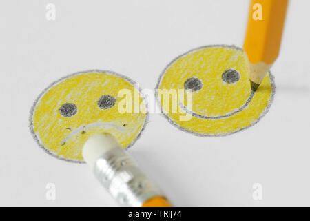 Dessin de smiley face à l'expression positive et négative avec le crayon et caoutchouc - Notion de positivité Banque D'Images