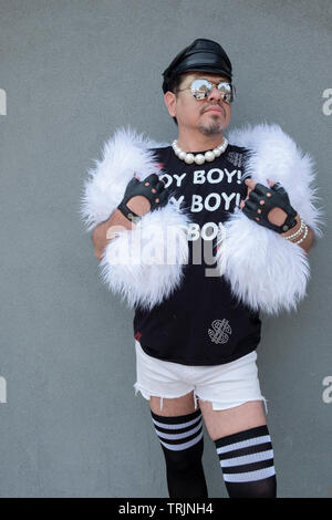 Posée portrait d'un homme vêtu d'un boa blanc et plus les chaussettes au Queens Pride Parade à Jackson Heights, Queens, New York. Banque D'Images